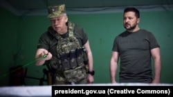 Генерал-полковник Олександр Сирський (ліворуч) доповідає президенту України Володимиру Зеленському на позиції біля лінії фронту на Донеччині, 26 червня 2023 року (архівне фото)