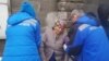 Kazakhstan - Medics are helping to the woman who fainted during the protest near the Chinese consulate. Almaty, 11 March 2021 