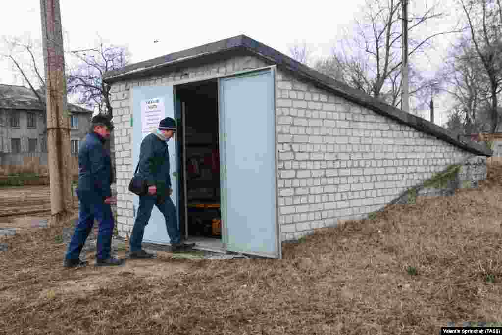 Ресейшіл сепаратистер бақылайтын аймақта трамвай депосы аумағында орналасқан бомбадан жасырынатын орынға кіріп бара жатқан адамдар.&nbsp;Донецк облысы, 24 наурыз 2021 жыл.
