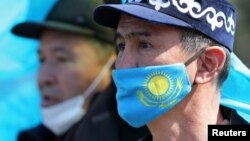 Маскасында Қазақстан туы бейнеленген ер кісі. Көрнекі сурет.