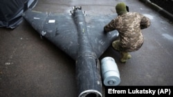 Офіцер ЗСУ оглядає збитий російський ударний безпілотник типу «Шахед», листопад 2024 року