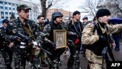 Separatiști pro-ruși purtând o icoană in fața clădirii ministerului de interne din Luhansk, 13 aprilie 2014